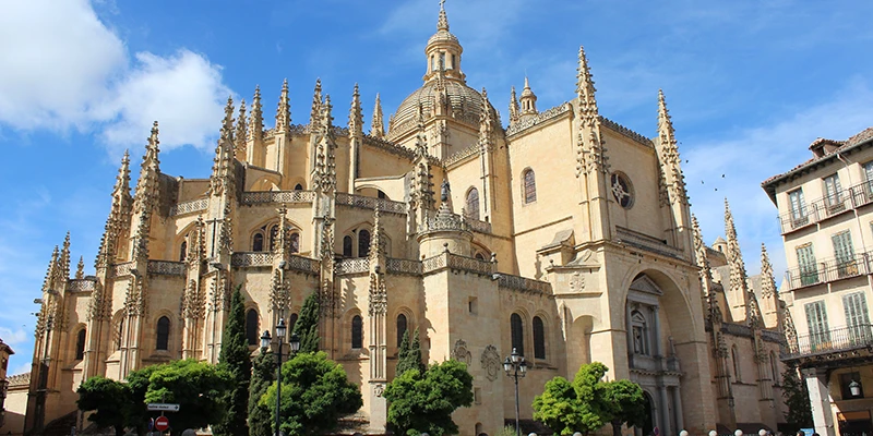 The flamboyant Gothic exterior of Segovia Cathedral with soaring buttresses and intricate stone tracery